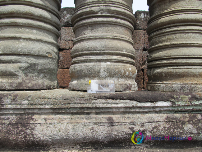 Маленький нано-картридж на под колоннами оконных проемов в разрушенном камбоджийском храме